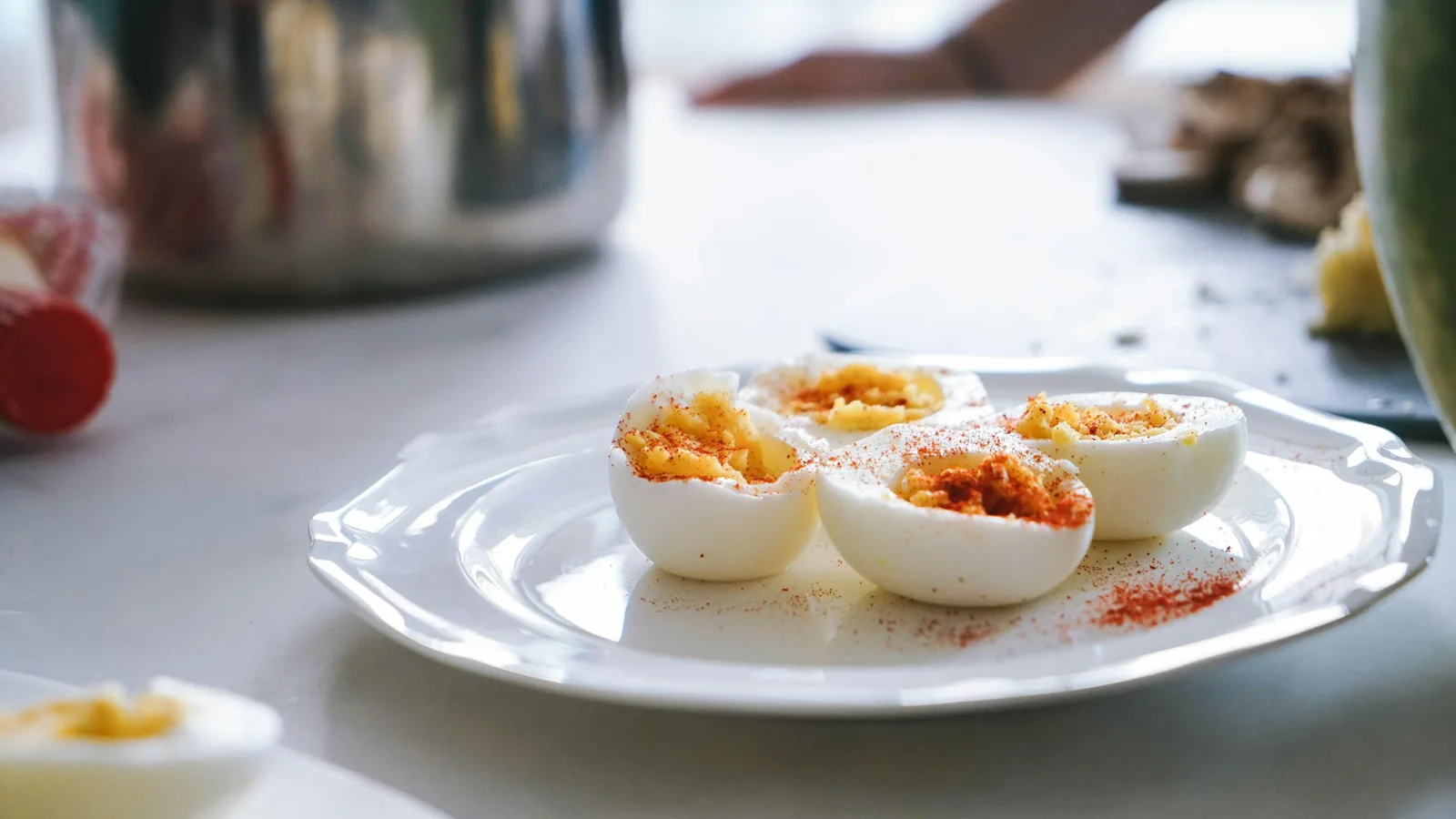 Halved hard-boiled eggs on a plate, yolks dusted with paprika.